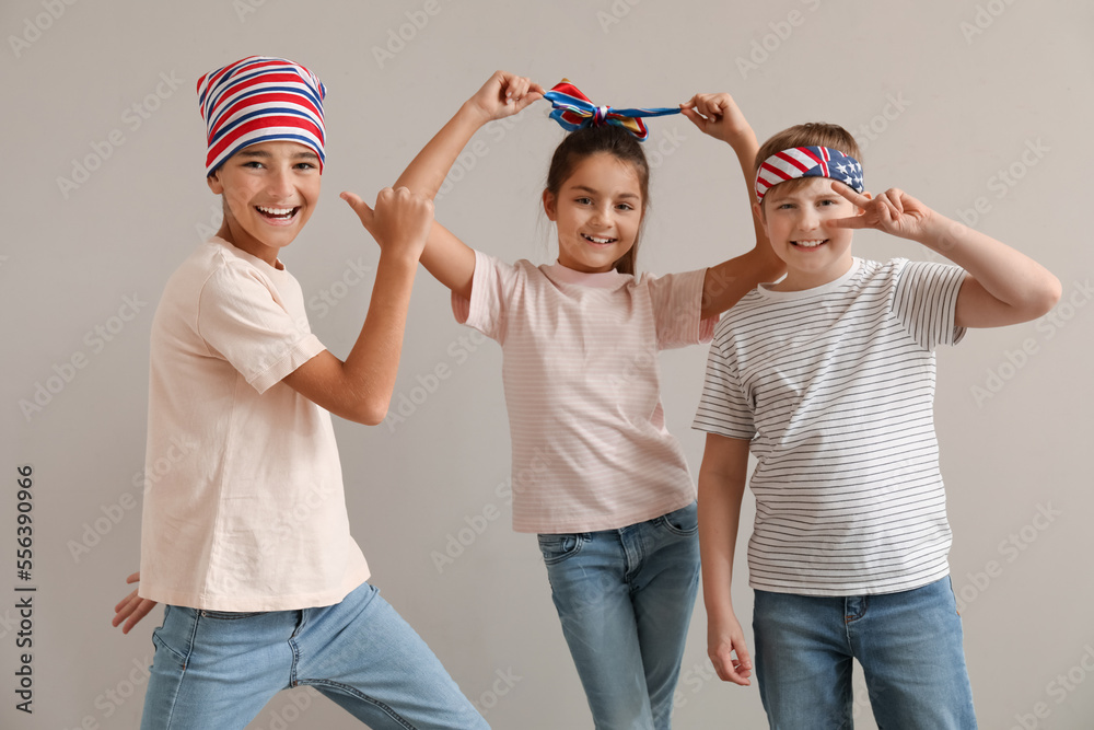 Happy little friends gesturing near grey wall