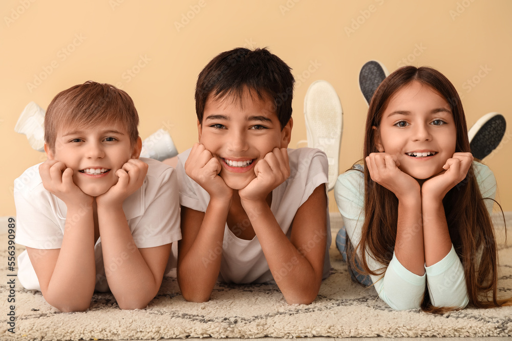 Little friends lying near beige wall