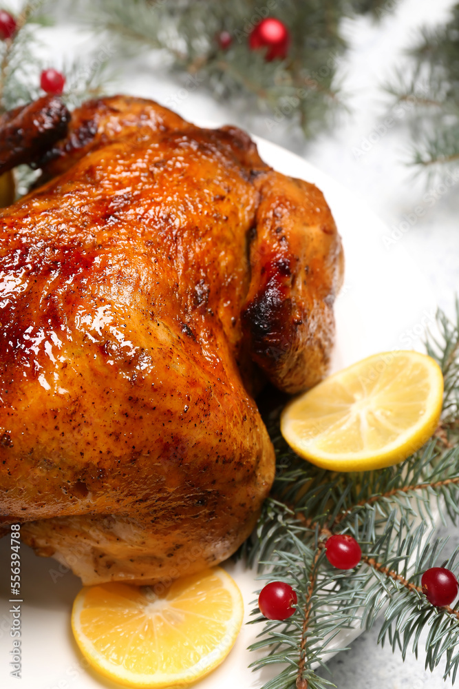 Plate with tasty chicken, lemon slices, berries and Christmas branches on white background, closeup