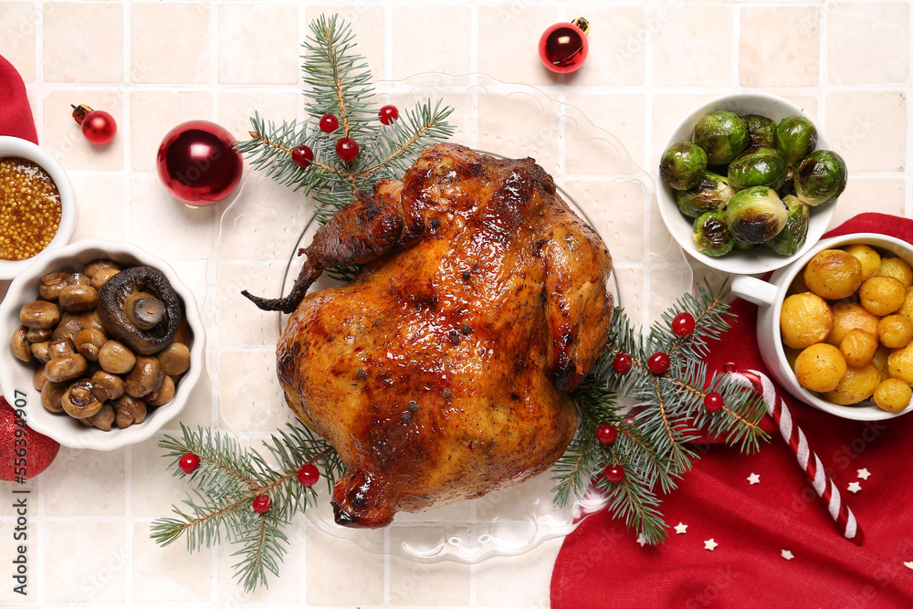 Plate with tasty chicken, garnish, spices and Christmas decor on beige tile background