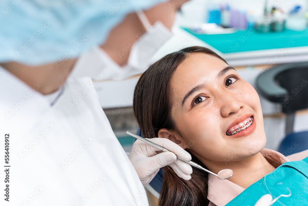 Orthodontist doctor examine tooth to woman patient at dental clinic. 