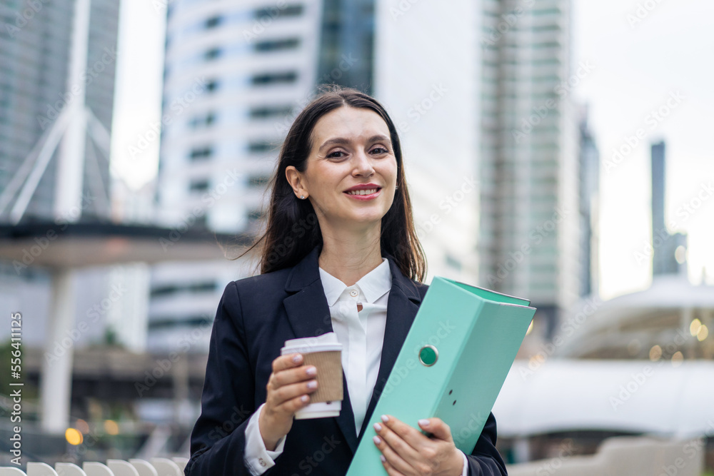 Portrait of Caucasian beautiful businesswoman standing outdoor in city. 