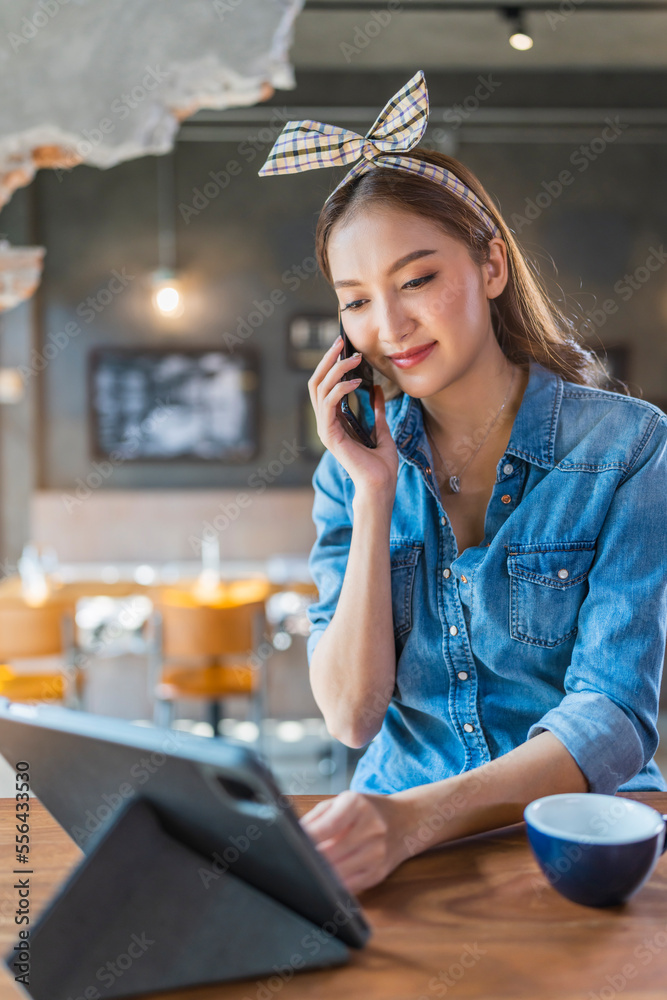 asian female cheerful woman hand using smartphone tablet working from kitchen at home while drink co