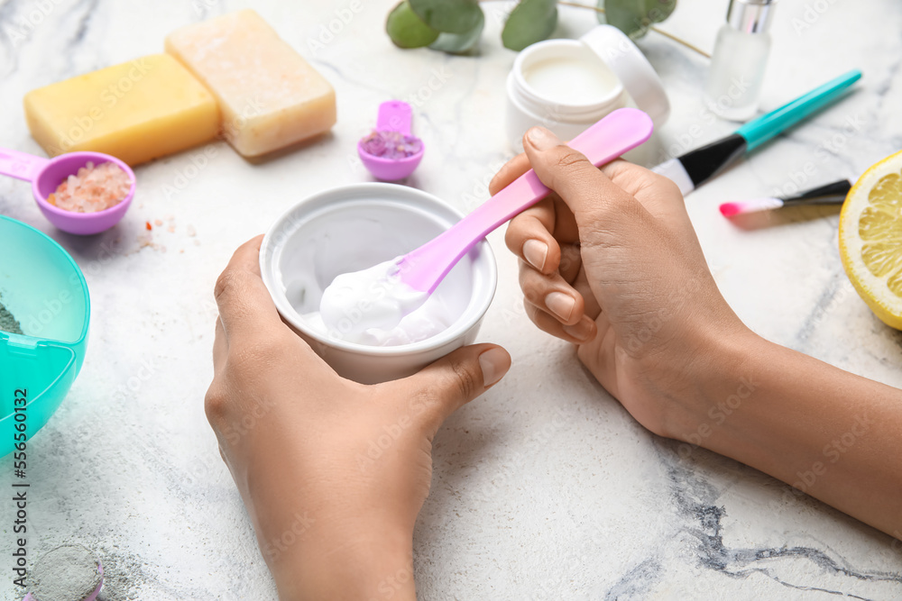 Woman preparing natural cosmetics on light background, closeup