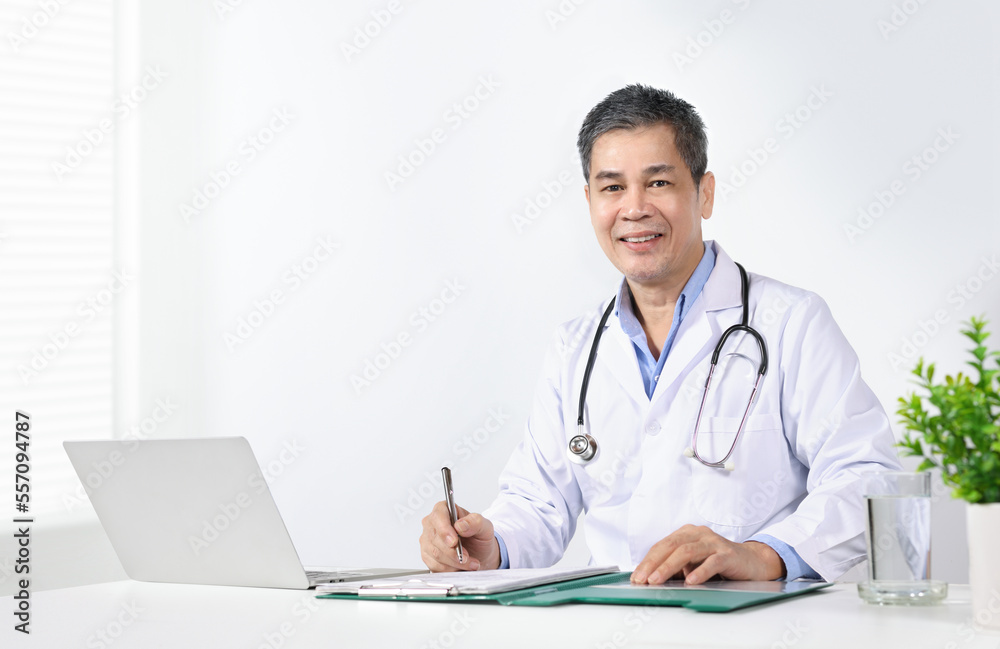 Asain male doctor writing document at office desk.