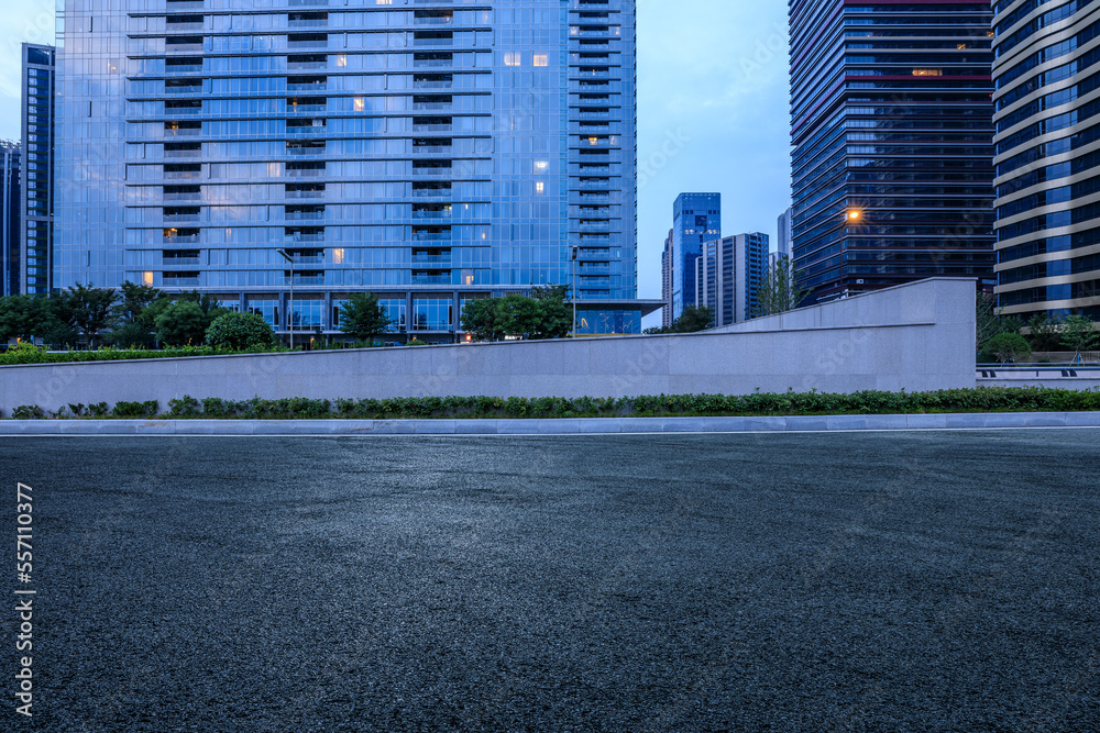 Asphalt road and city skyline with modern commercial buildings in Shanghai at night, China.