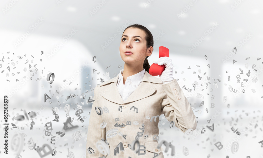 Attractive woman holding vintage red phone