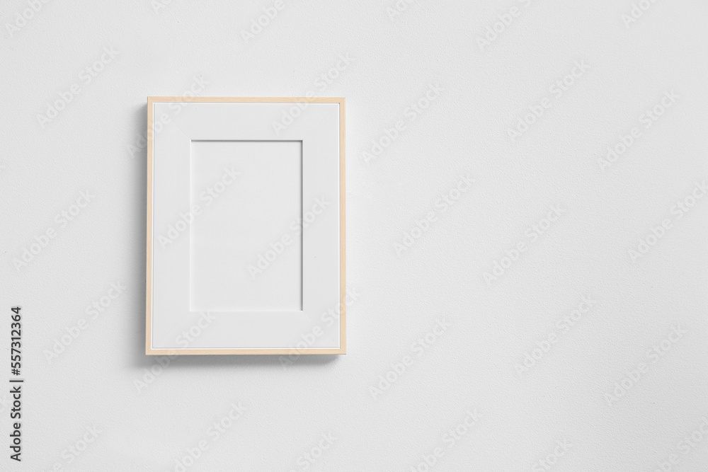 Blank photo frame on white wall