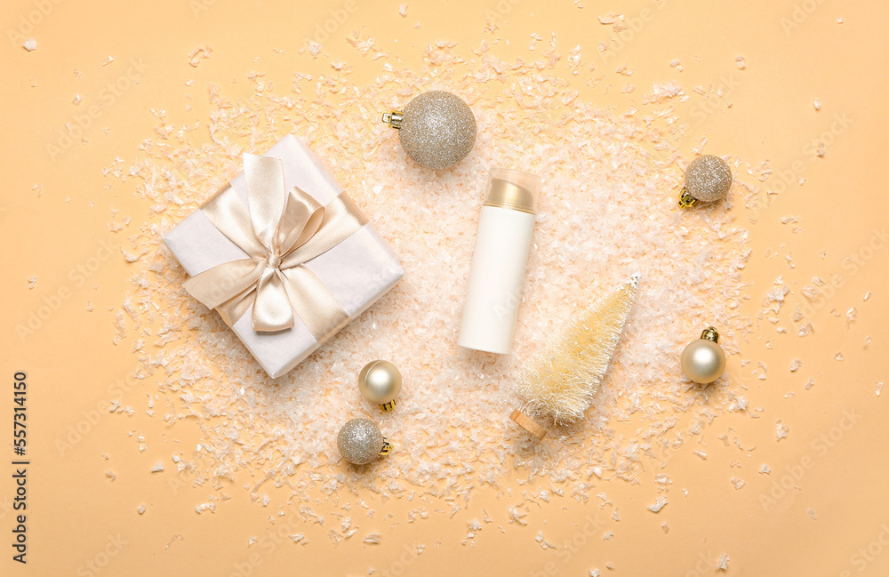 Composition with bottle of cosmetic product, Christmas decorations, gift box and snow on color backg