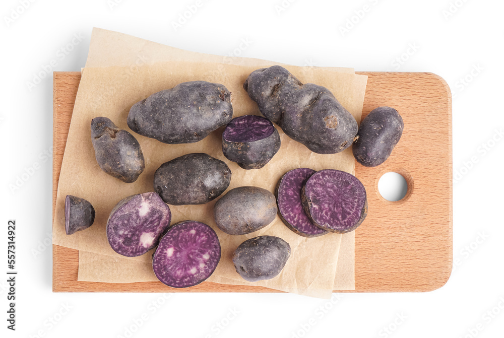 Board of raw purple potatoes on white background