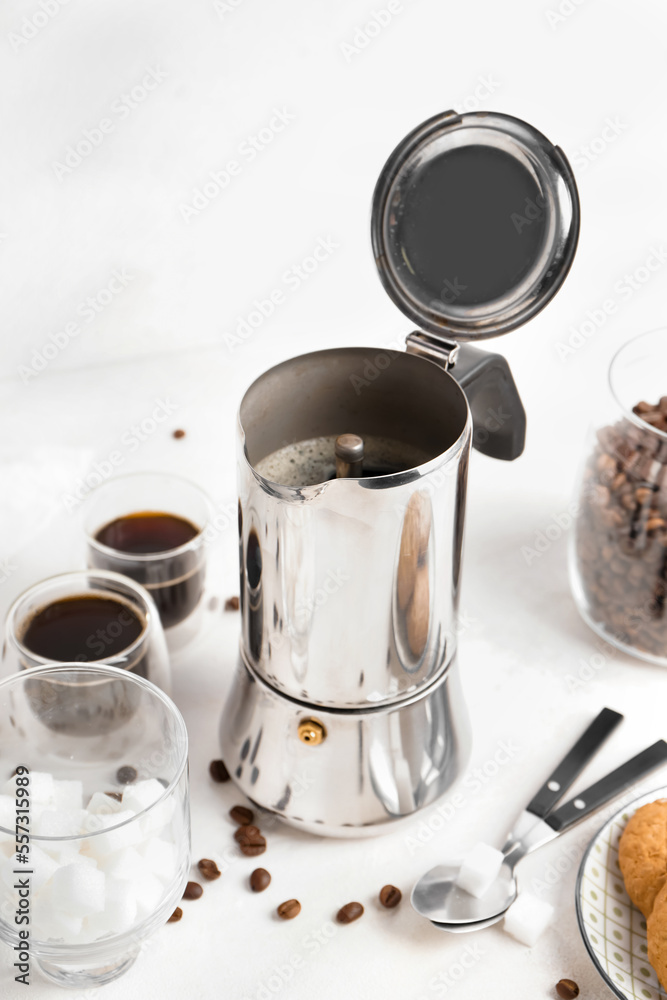 Geyser coffee maker, glass of espresso and beans on white background