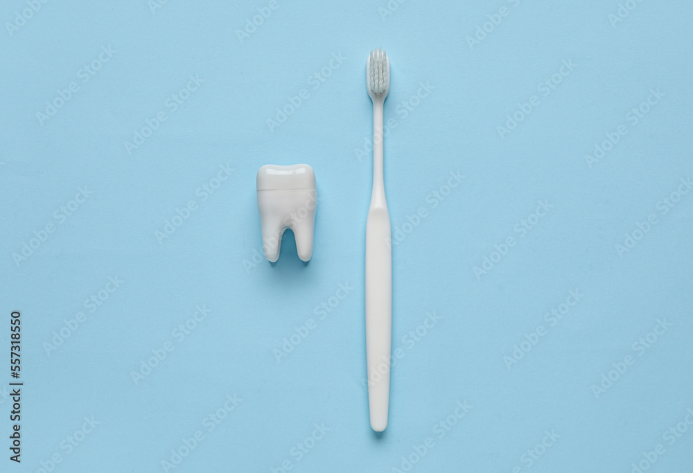 Plastic tooth with brush on blue background