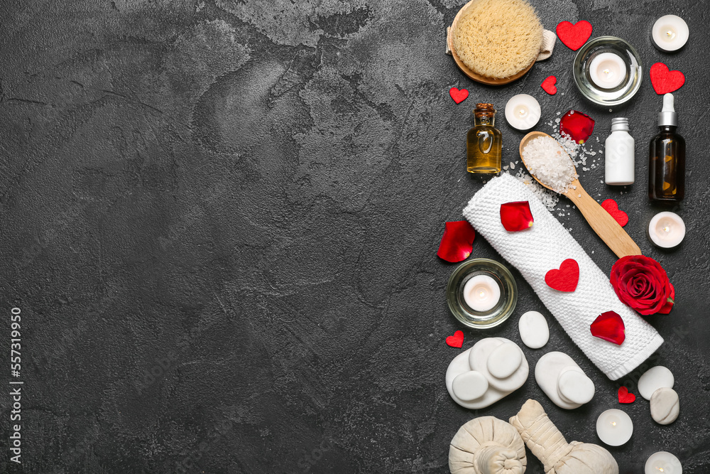 Spa composition for Valentines Day with stones, rose petals and hearts on black background