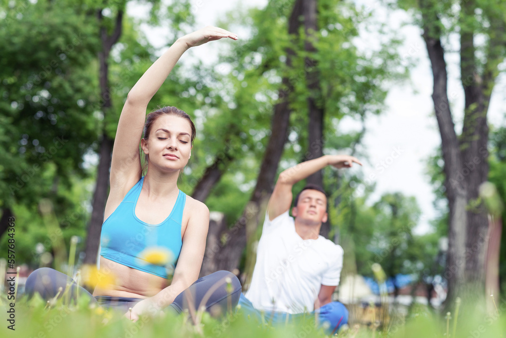 Couple of young sporty people practicing yoga