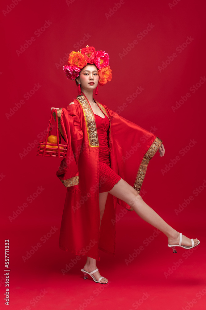 亚洲年轻女性的全身画像，穿着时尚的现代qipao-cheonam连衣裙微笑着，飘逸着