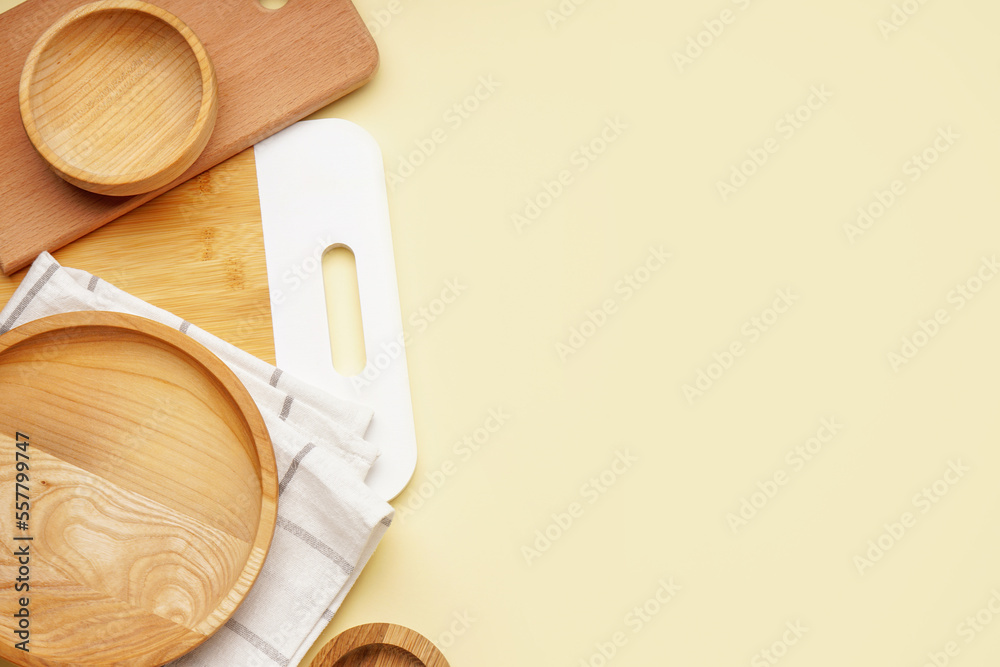 Wooden plates and boards on yellow background