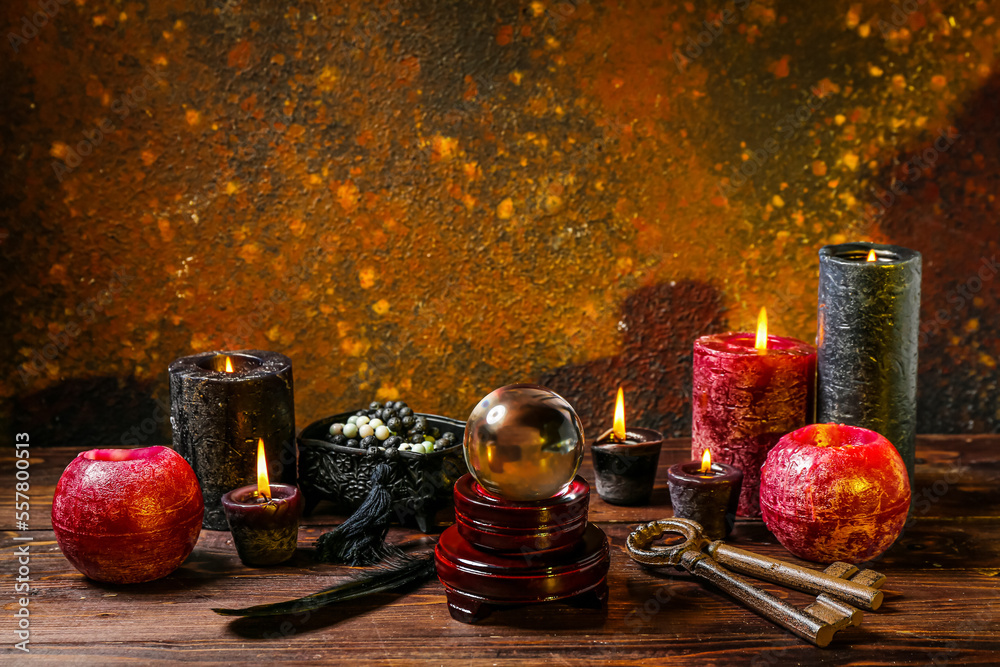 Crystal ball and magic attributes of fortune teller on wooden table