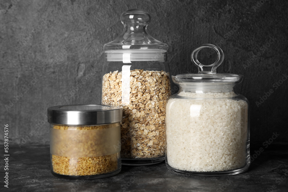 Jars with cereals on dark background