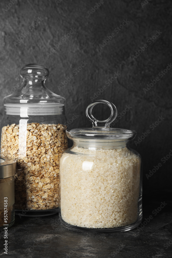 Jars with cereals on dark background, closeup