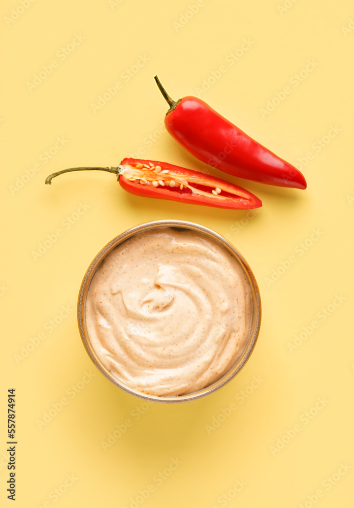 Bowl of tasty chipotle sauce on yellow background