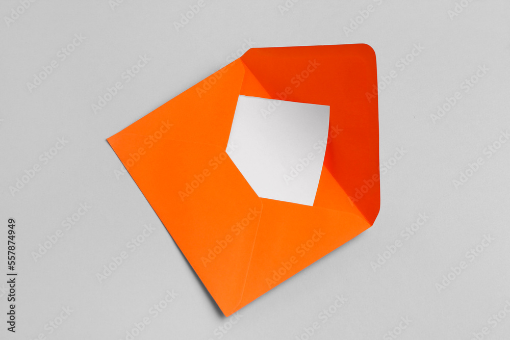 Orange envelope with blank card on grey background