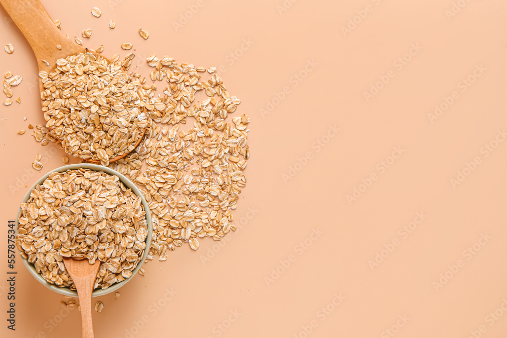 Bowl and spoons of raw oatmeal on color background