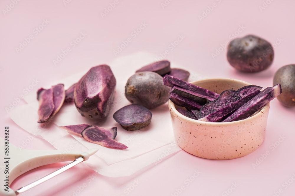 Bowl of cut purple potatoes on pink background