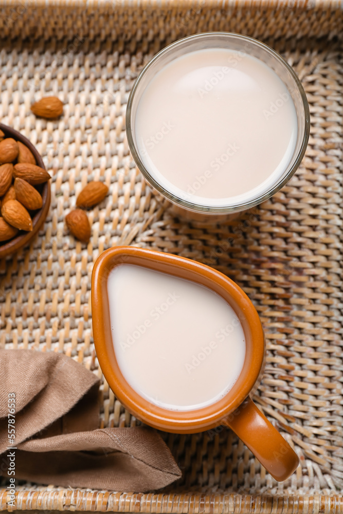 Tray with jug and glass of almond milk, closeup