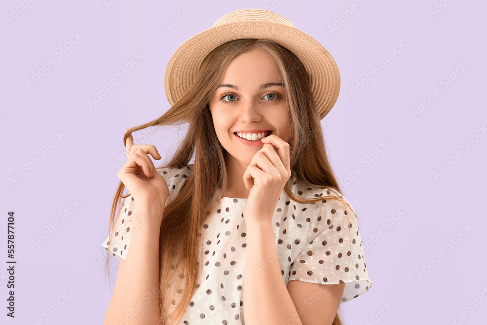 Young woman in hat biting nails on lilac background, closeup