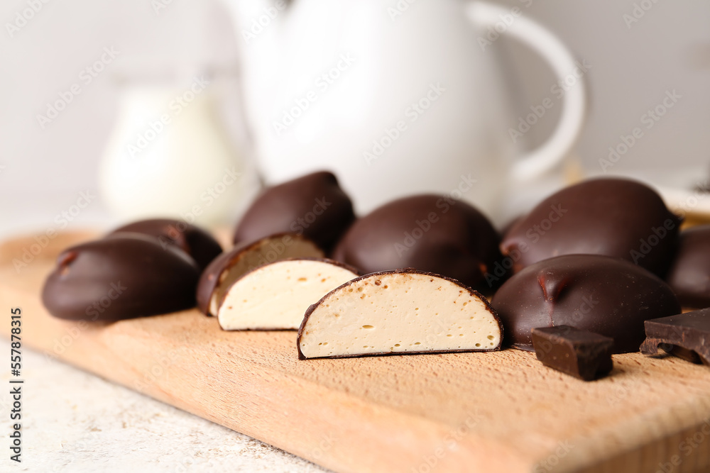 Cutting board with sweet chocolate birds milk candies, closeup