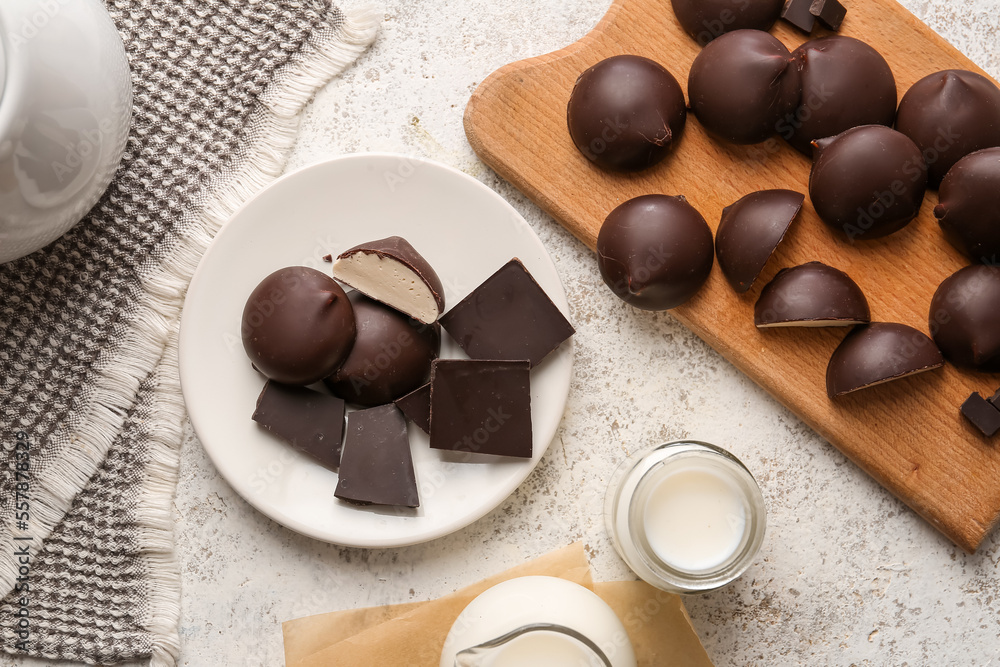 Plates with sweet chocolate birds milk candies and jugs of milk on kitchen table