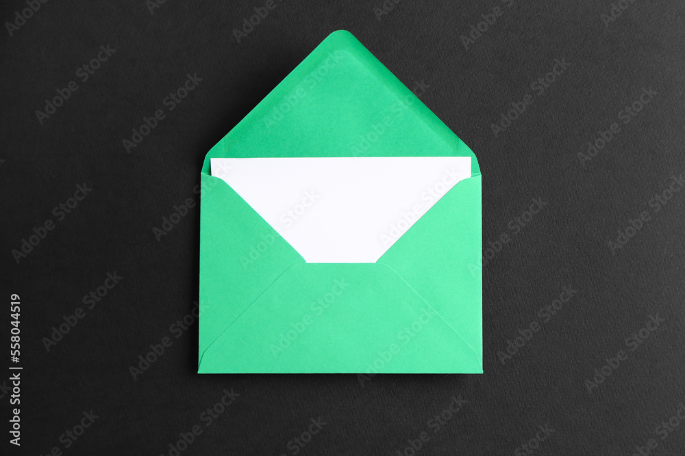 Green paper envelope with card on dark background