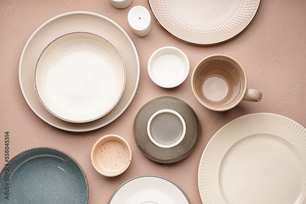 Different clean dishware on beige background