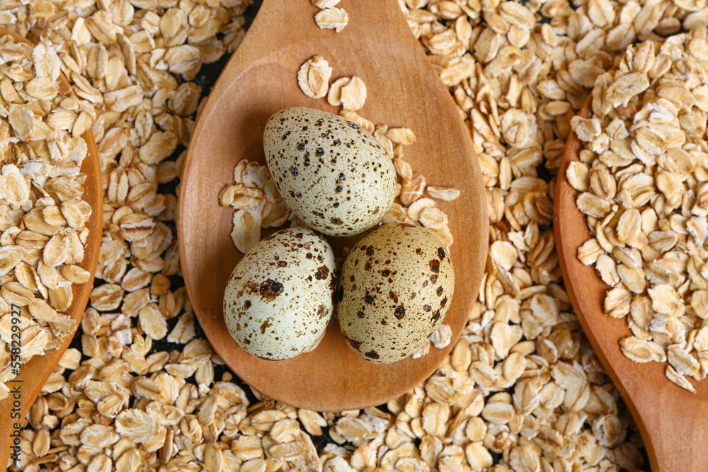 Spoons with raw oatmeal and quail eggs, closeup