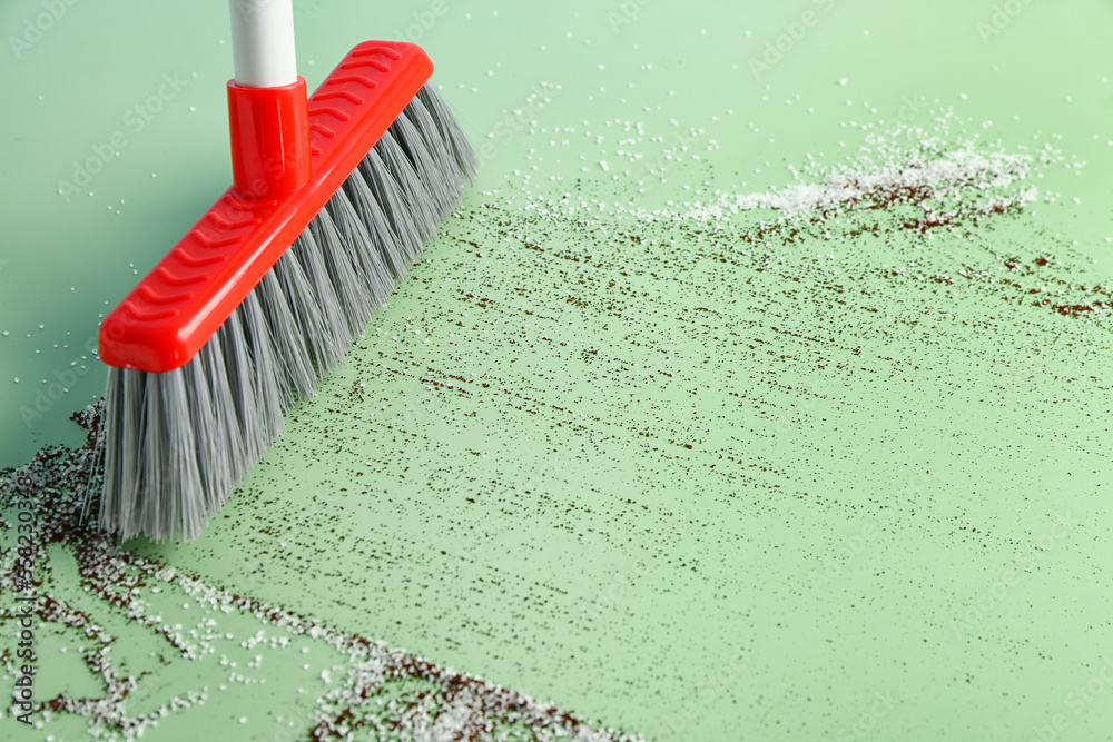 Sweeping of rubbish with broom on color background, closeup