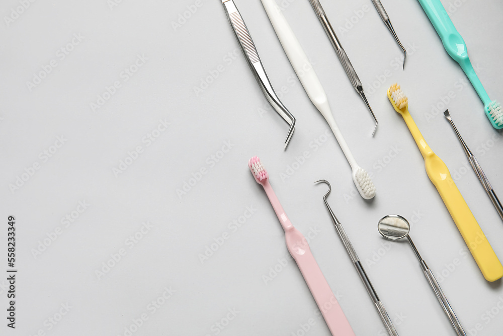 Dental tools with toothbrushes on grey background