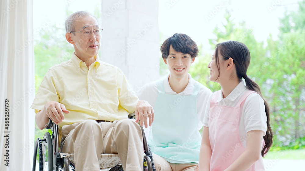 車椅子に乗った高齢者を介護するヘルパー