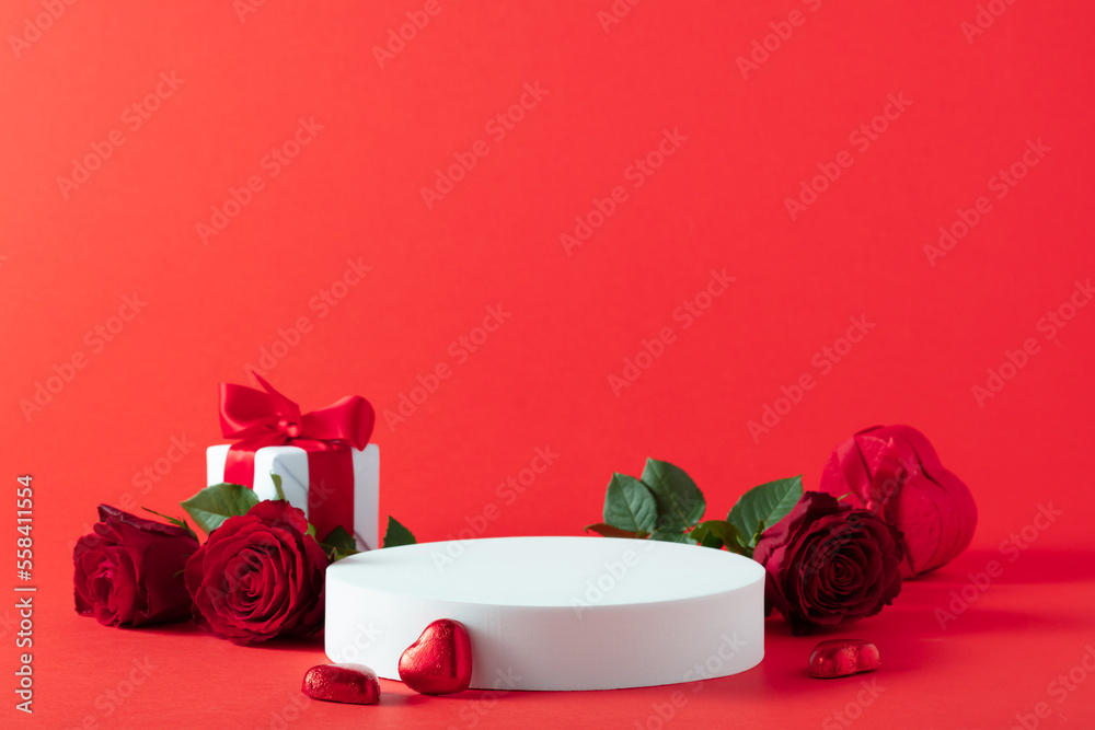 Abstract empty white podium with heart and rose flowers on red background. Mock up stand for product