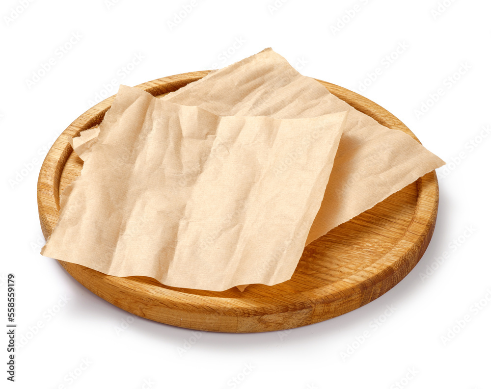 Baking paper on wooden board isolated. Round board with crumpled pieces of brown parchment or baking