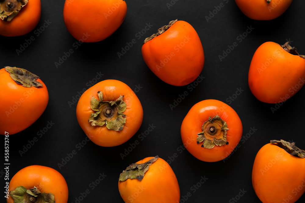 Fresh ripe persimmons on dark background