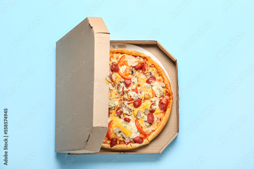 Cardboard box with delicious pizza on color background