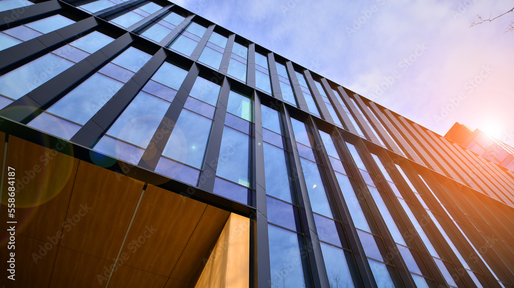 Glass modern building with blue sky background. Low angle view and architecture details. Urban abstr