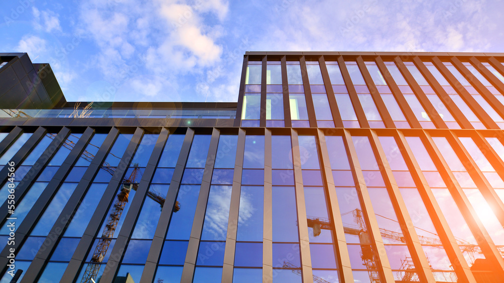 Glass modern building with blue sky background. Low angle view and architecture details. Urban abstr