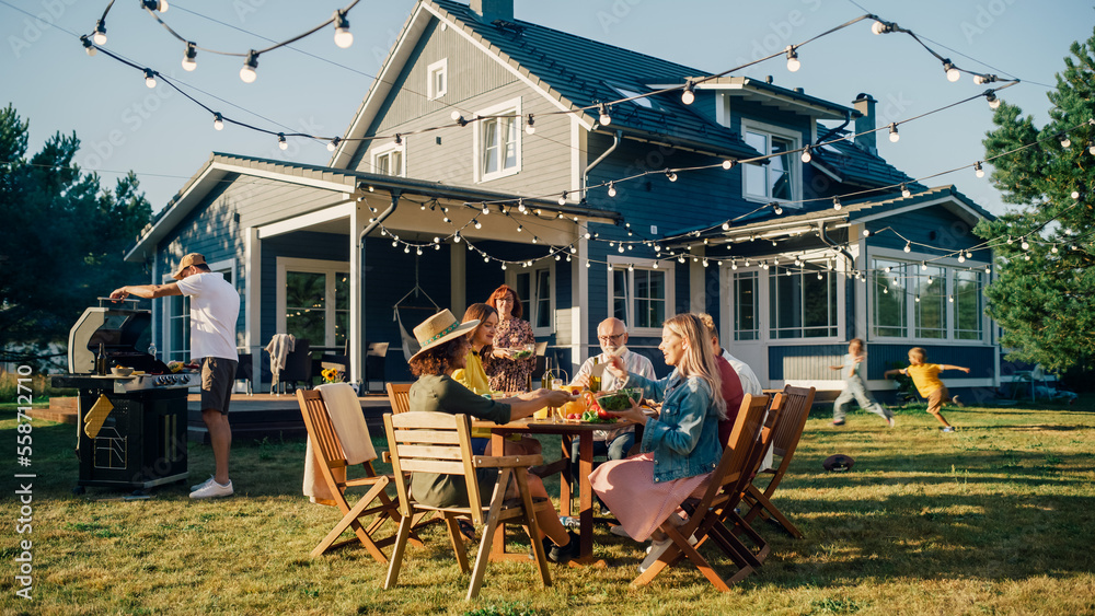 Parents, Children and Friends Gathered at a Barbecue Dinner Table Outside a Beautiful Home. Multicul