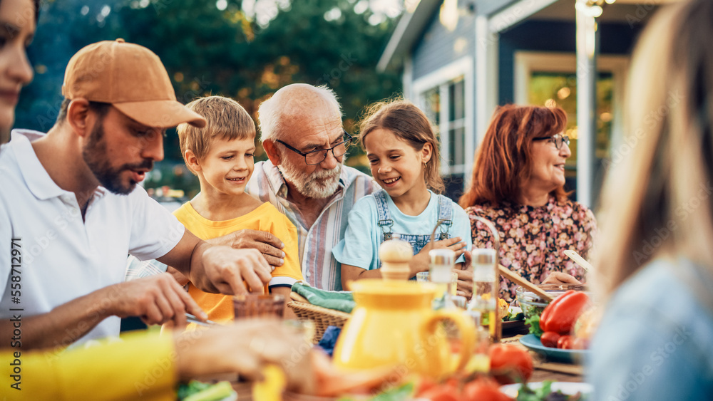 Portrait of a Happy Senior Grandfather Holding His Bright Talented Little Grandchildren on Lap at a 