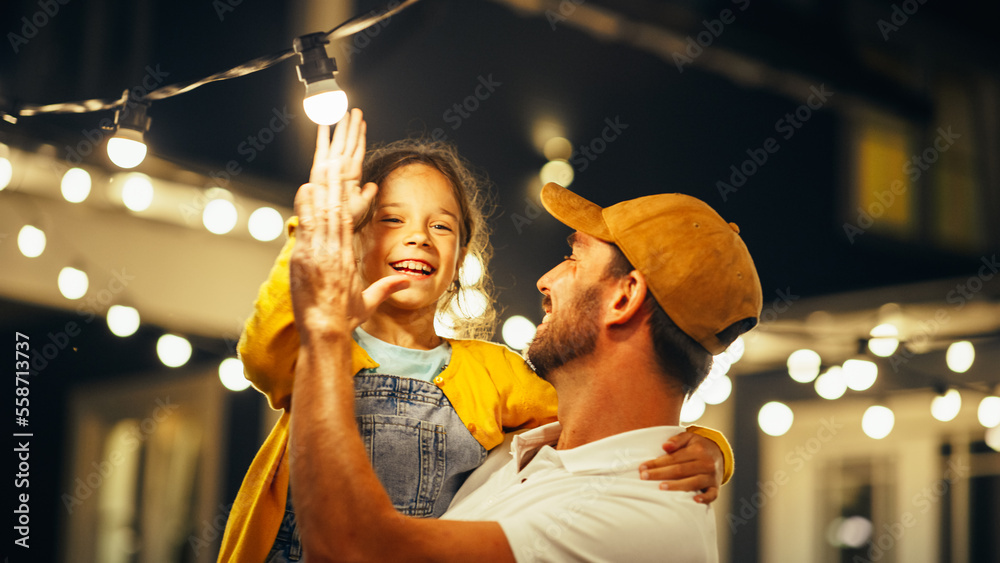 Proud Handsome Father Helping His Little Beautiful Daughter to Change a Lightbulb in Fairy Lights Ba