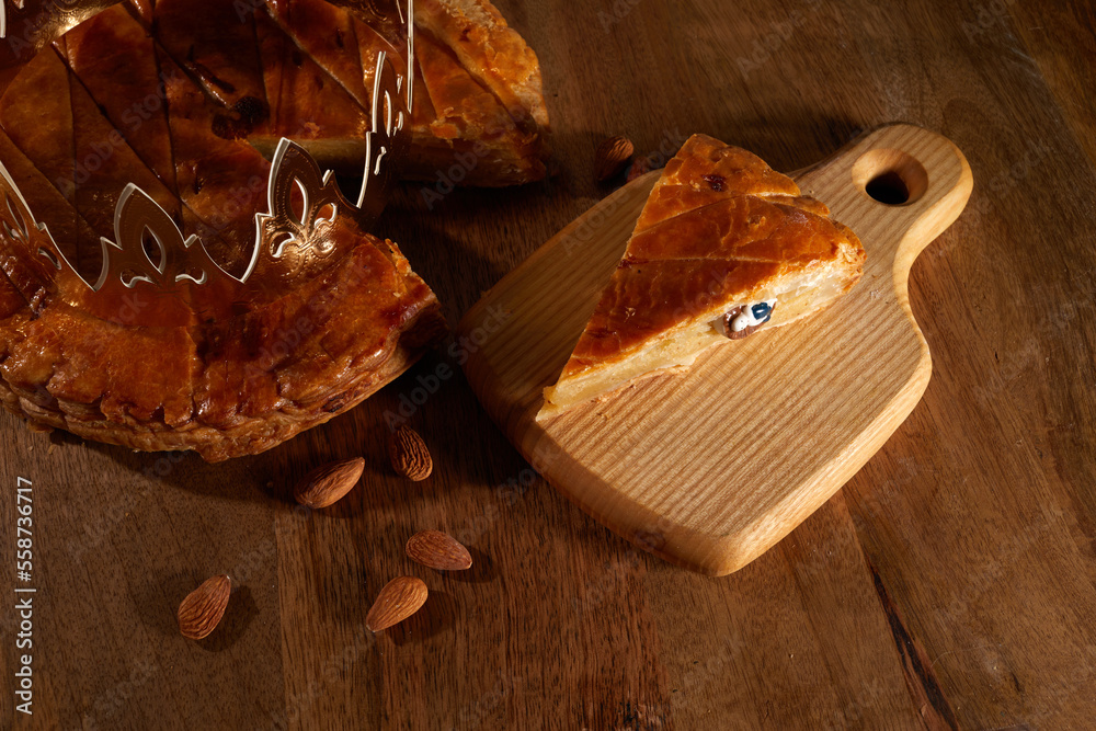 King cake or galette des rois in French. Epiphany pie with golden paper crown and little ceramic fig