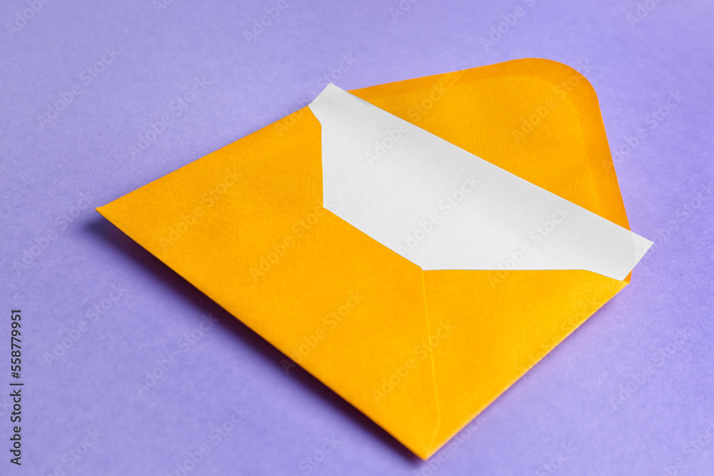 Yellow paper envelope with card on lilac background