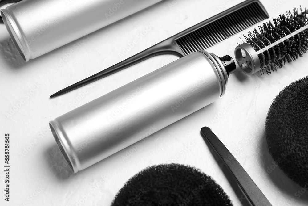 Hair spray with comb on white background, closeup