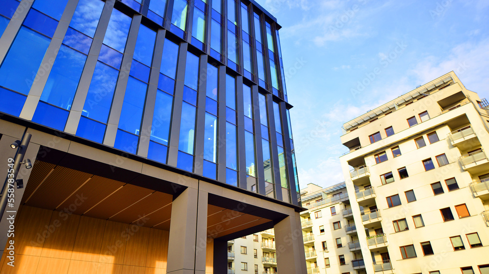 Glass modern building with blue sky background. Low angle view and architecture details. Urban abstr